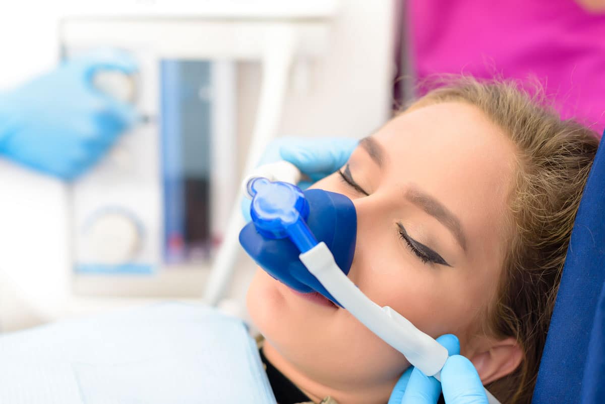 woman in dental chair receiving sedation